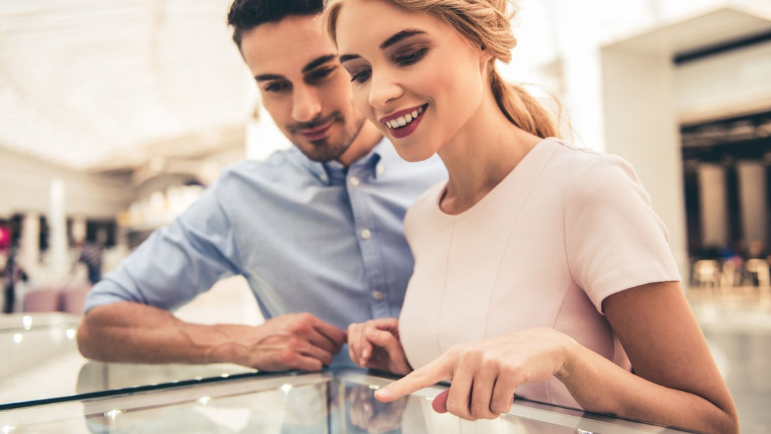 Couple examining a piece of jewellery together at a jeweller's showroom