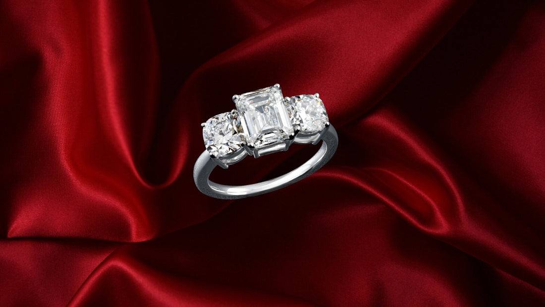 Three-stone diamond trilogy ring displayed against red velvet fabric