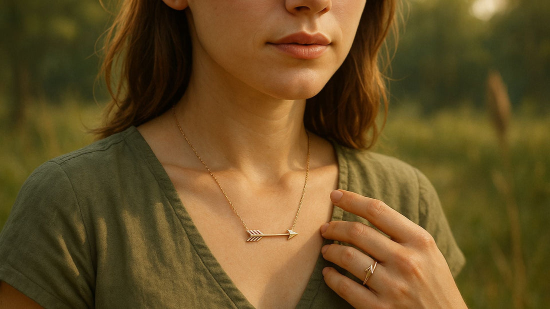 Woman in a green top wearing a minimal arrow pendant necklace in a sunlit meadow