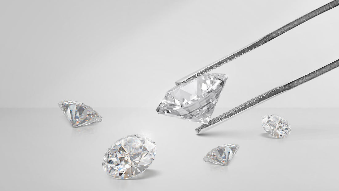 Loose clear diamonds and a precision cutting tool arranged on a white surface