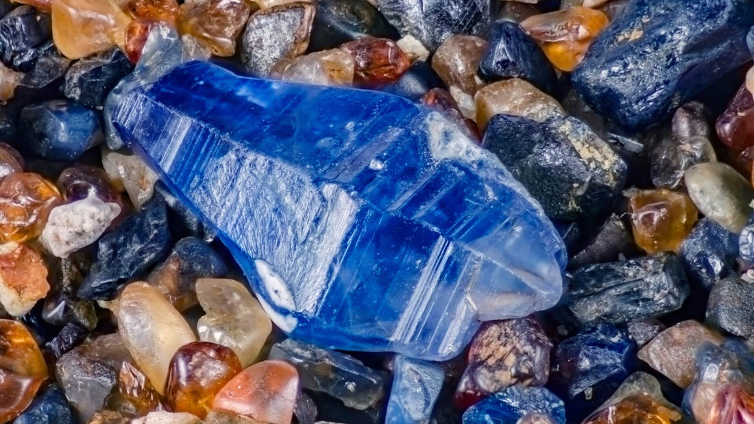 Blue sapphire crystals and rough gemstones arranged with natural mineral fragments