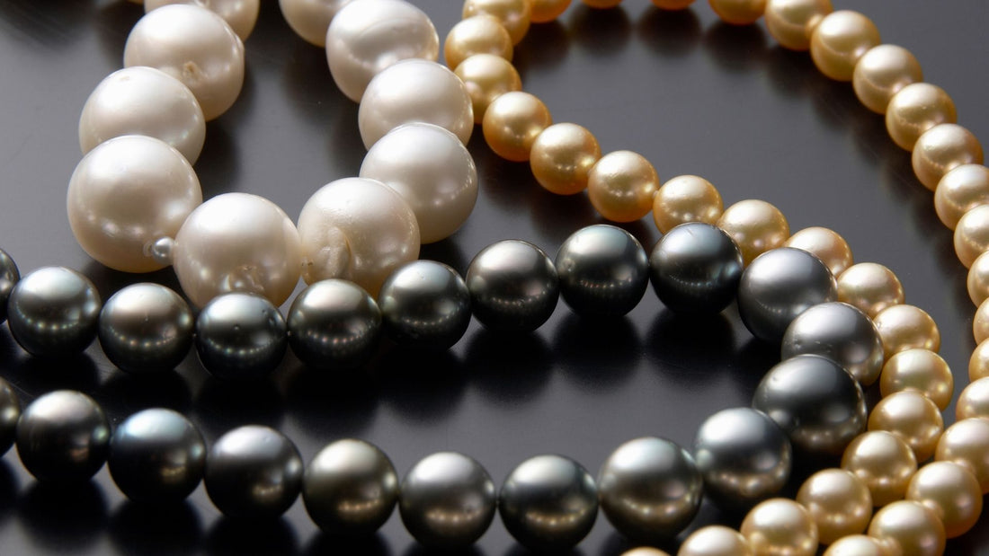 Strands of white, grey and golden pearls arranged together to show pearl varieties