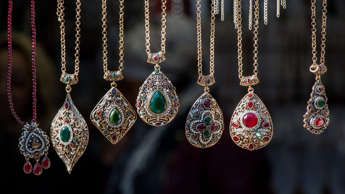 Collection of antique pendant necklaces and historic jewellery displayed against a dark background