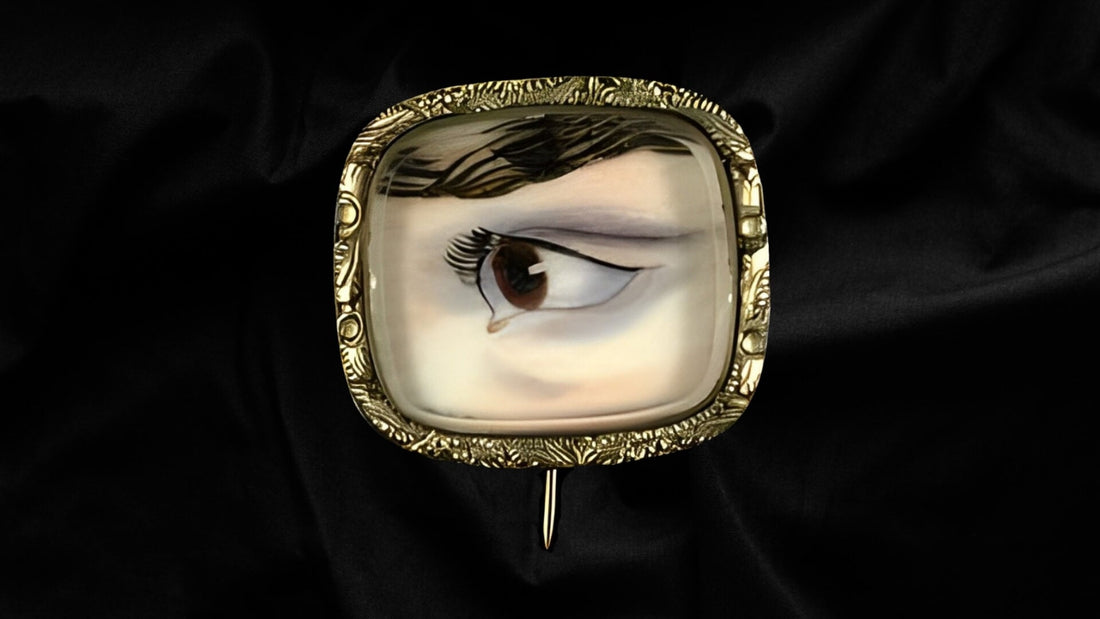 Antique gold lover's eye ring with a painted eye miniature under glass against black velvet