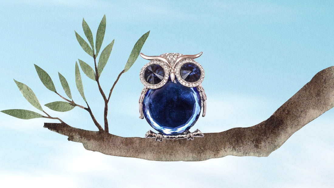 Illustrated owl perched on a tree branch beside a bright blue sky