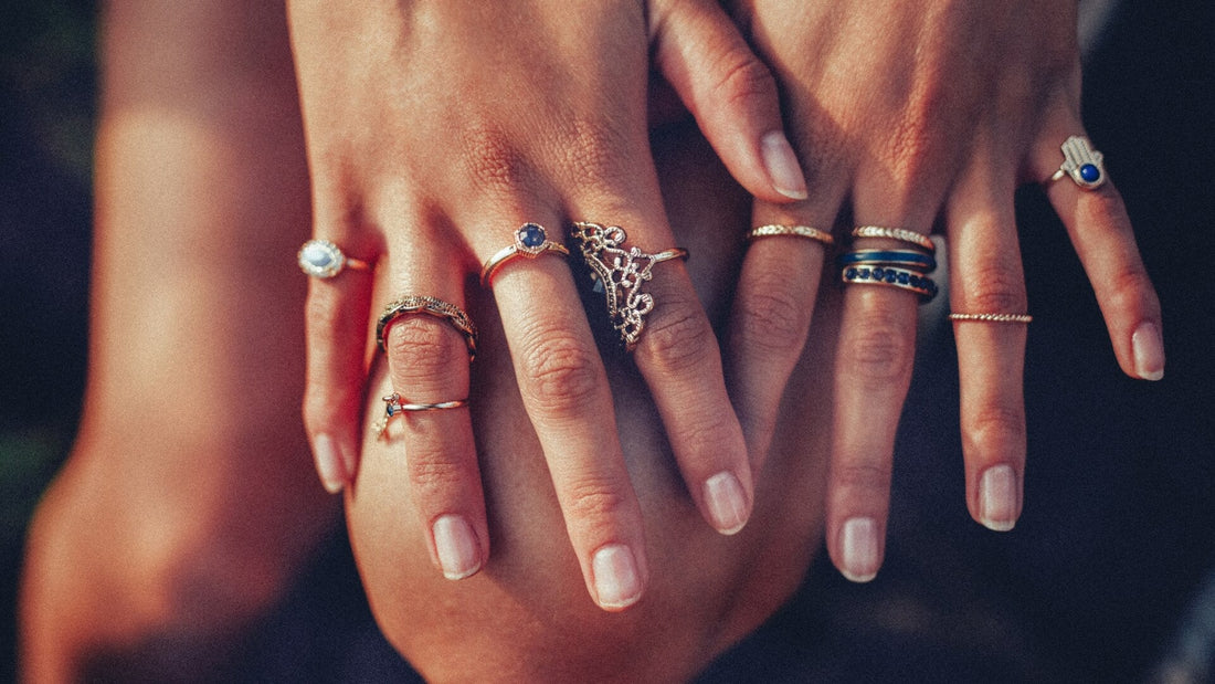 Hands adorned with several gold and silver rings, illustrating wearing rings on both hands