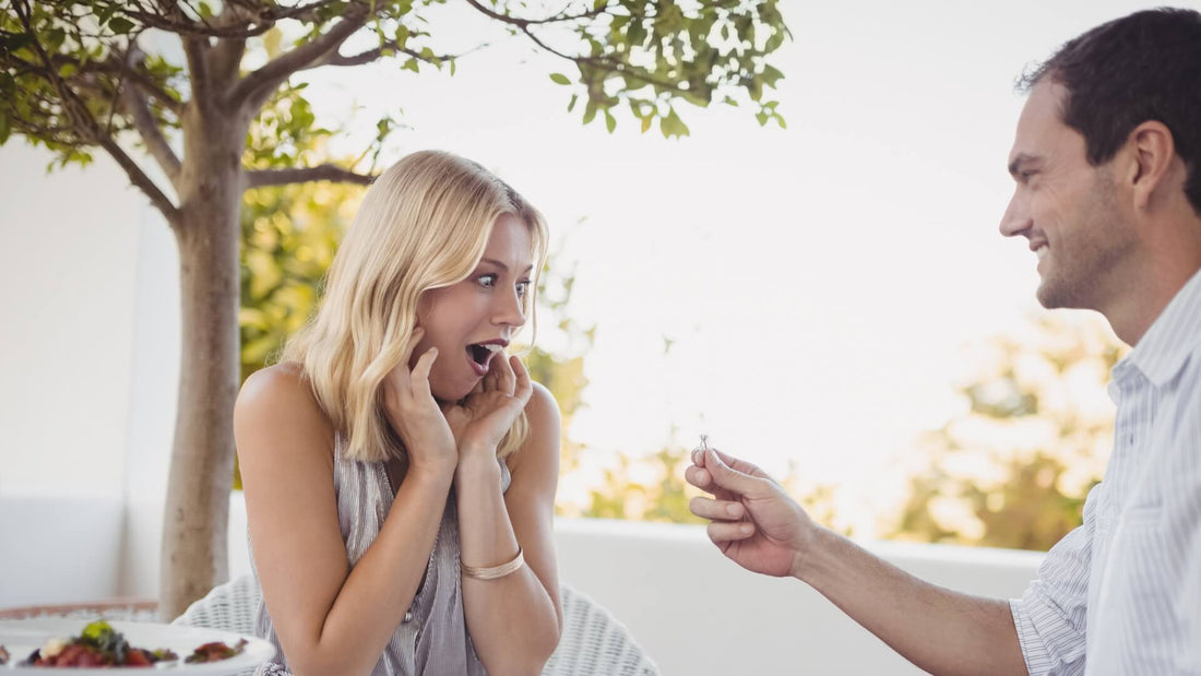 Man showing his partner an engagement ring during a surprise outdoor proposal