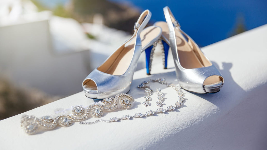 White bridal shoes and sparkling jewellery laid together on a pale display