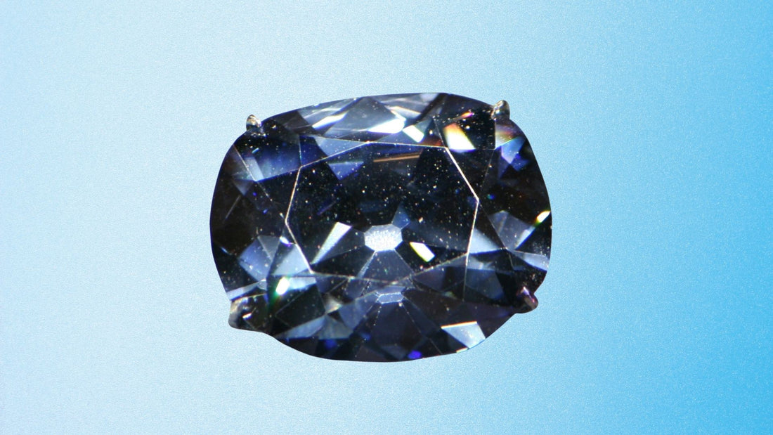 Deep blue Hope Diamond sparkling against a pale blue background