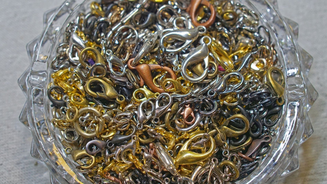 Collection of metal jewellery clasps and fasteners spread across a grey surface