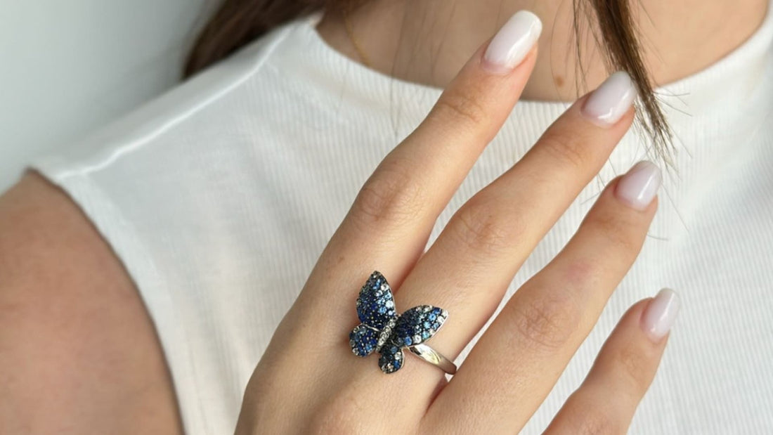 Butterfly-shaped jewellery with shimmering blue gemstones worn on a hand