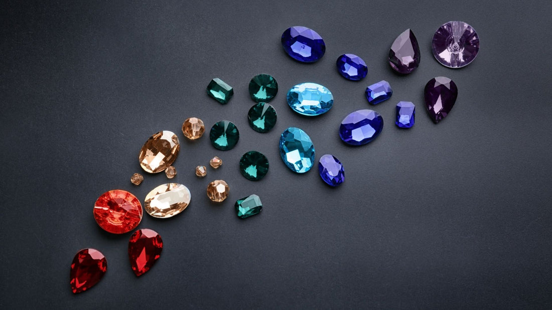 Loose rubies, sapphires, emeralds and other colourful gemstones arranged on a dark background