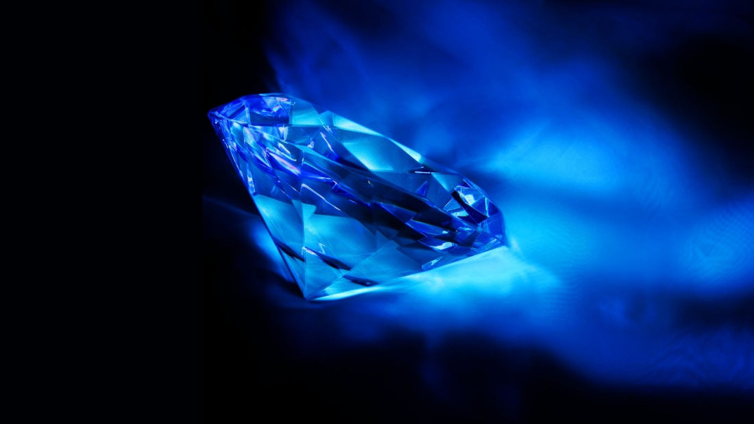 Brilliant diamond glowing electric blue under ultraviolet light, illustrating diamond fluorescence