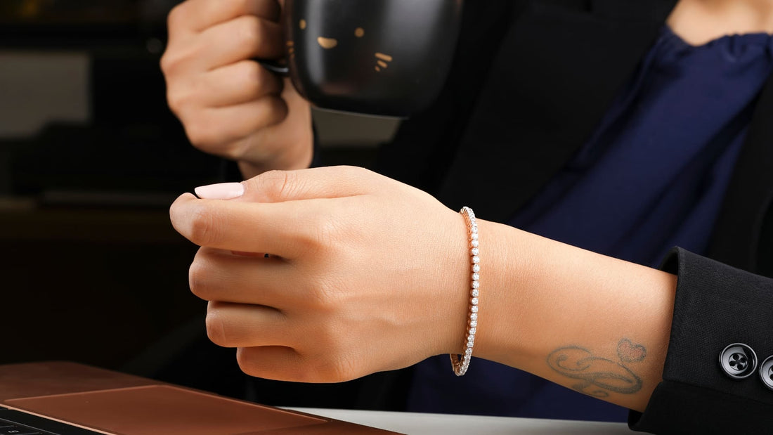 Close-up of a hand wearing a classic gold band alongside a dark tailored jacket, showing timeless jewellery styling