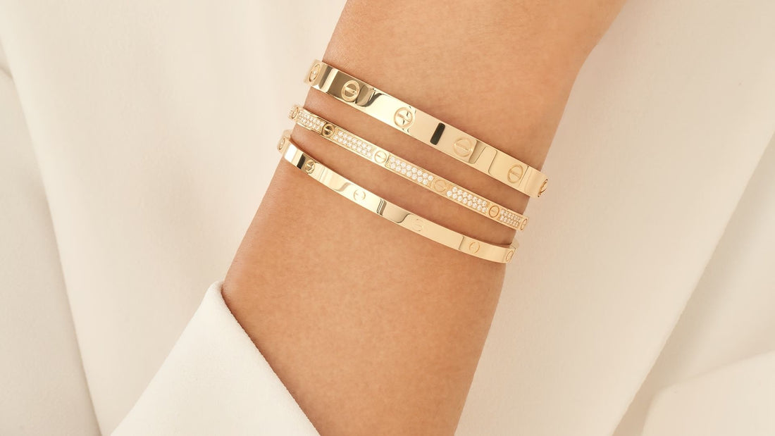 Close-up of a classic gold Cartier Love bracelet worn on a wrist