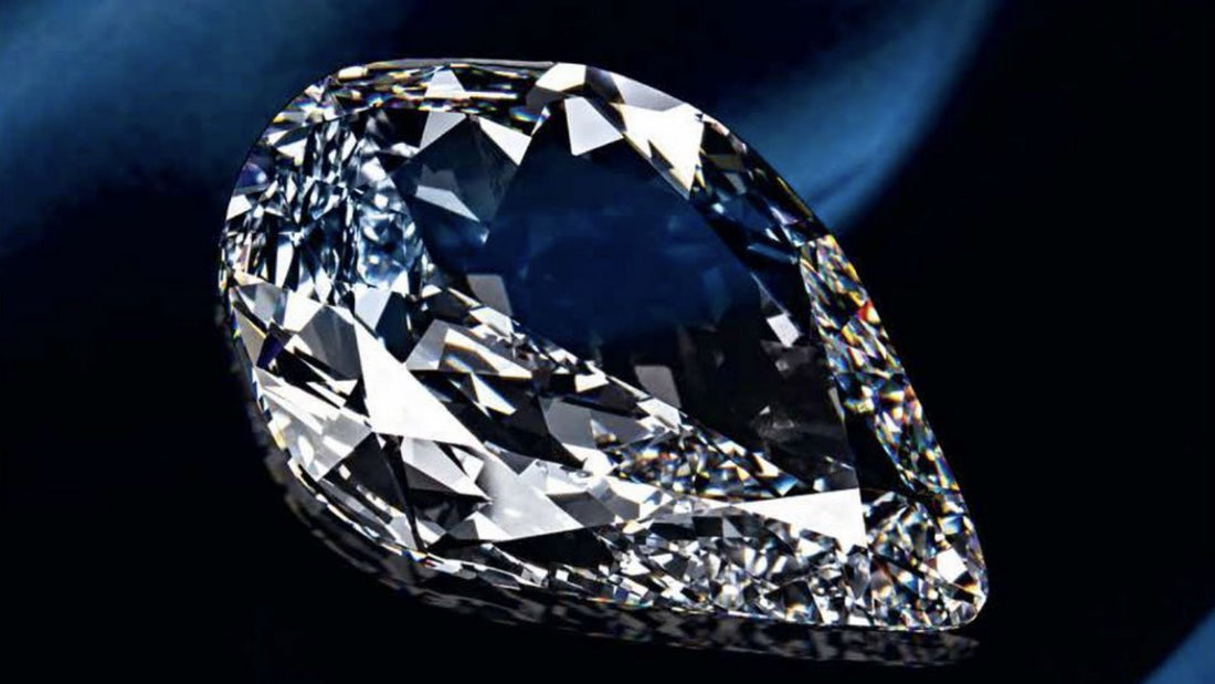 Large sparkling colourless diamond viewed against a deep navy background, illustrating the Koh-i-Noor legend