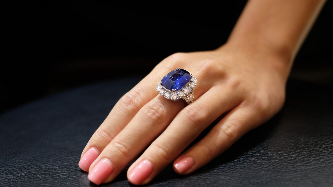 Close-up of a hand wearing a sapphire gemstone ring, highlighting September's blue birthstone