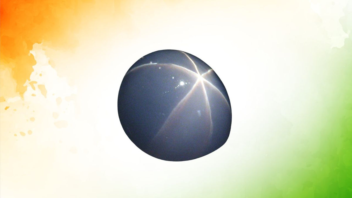 Deep blue star sapphire cabochon showing a pale six-rayed star across its surface