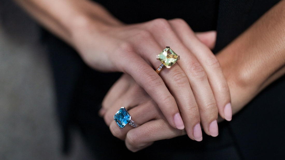 Hands displaying colourful gemstone rings, illustrating the cultural symbolism of stone colours