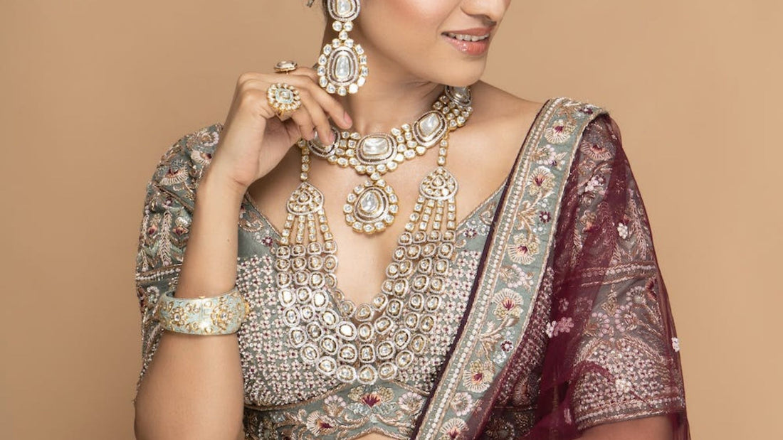Woman in traditional Indian attire modelling layered kundan and polki necklaces and earrings