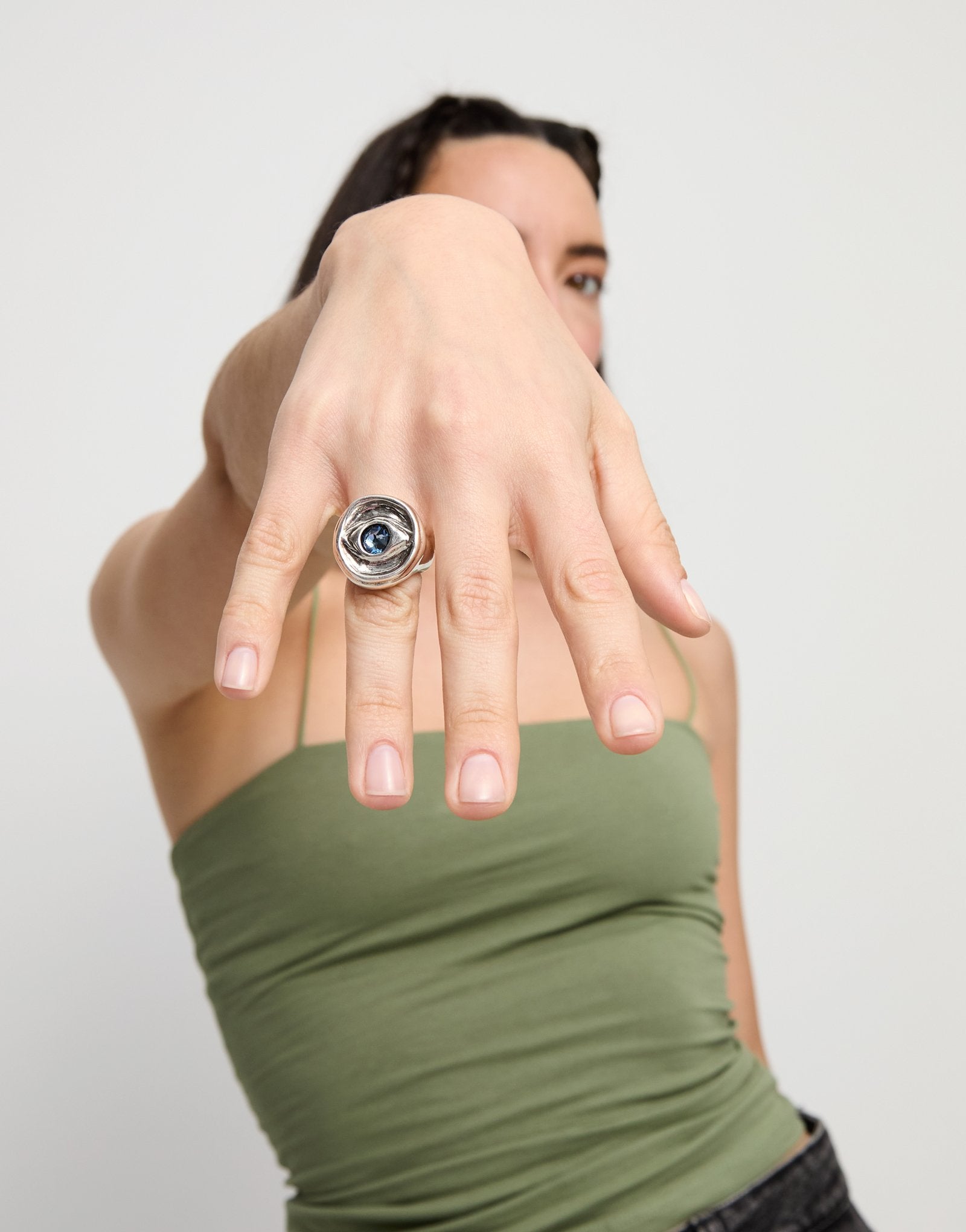 Eye-shaped ring with faceted blue crystal