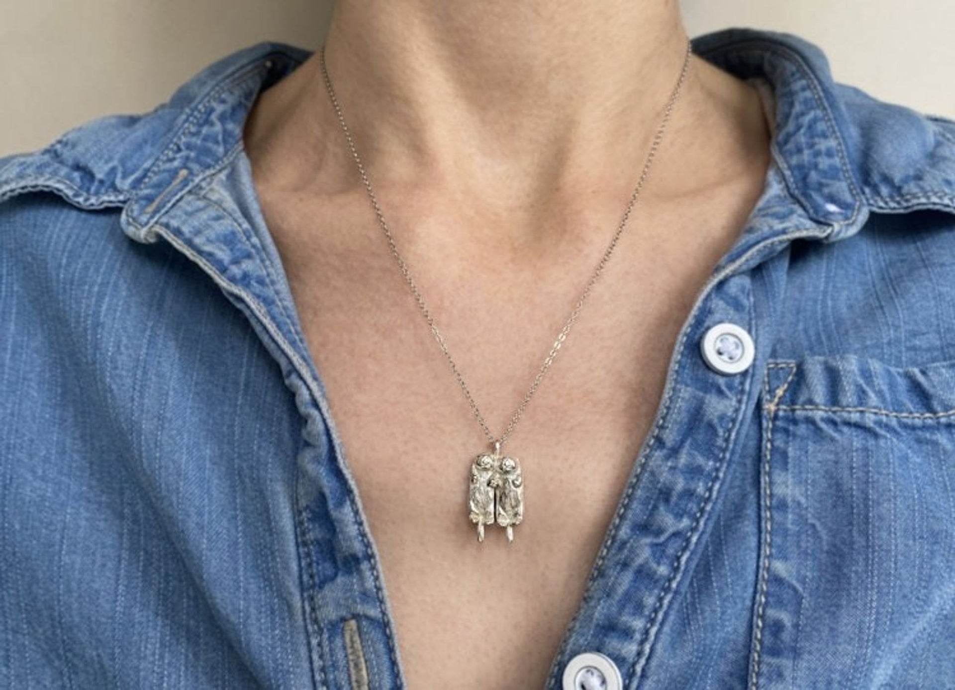 Two Silver Otters Holding Hands Necklace